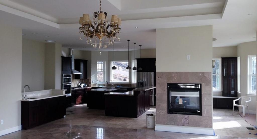 A contemporary french style family room with beige marble tiled floor and a two way fireplace